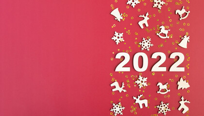 Wooden numbers for new year 2022 with stars and christmas decor on red background with copy space. Banner format
