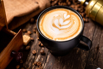 Cup of coffee with milk latte decoration of a rosette on top placed on a wooden table