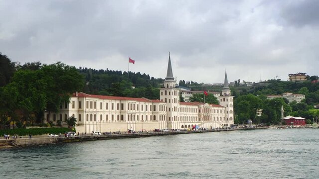 Military High School building with tower and flags of Turkey on seashore of Bosphorus strait, Istanbul, Turkey.