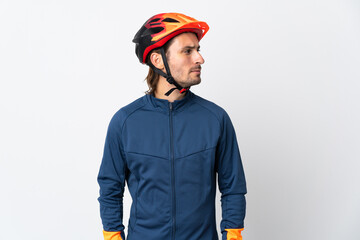 Young cyclist man isolated on white background looking to the side
