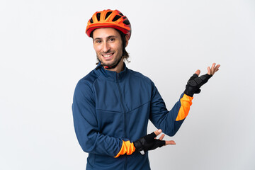 Young cyclist man isolated on white background extending hands to the side for inviting to come - obrazy, fototapety, plakaty