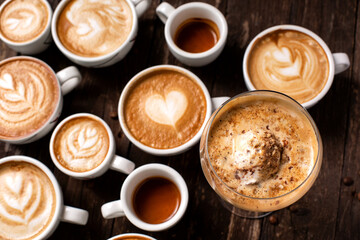 Upper view of various coffee drinks, from latte to macchiato on rustic wooden background