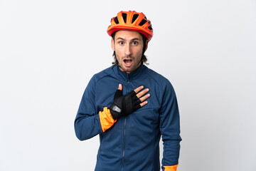 Young cyclist man isolated on white background surprised and shocked while looking right