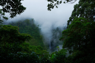 Fototapeta na wymiar Costa Rica San Fernando Waterfall in the cloud forest, green jungle, view from the air and from the hill. Cinchona restaurant mountain landscape view, fog and clouds above the waterfall in the jungle