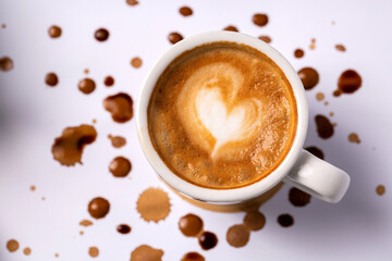 Heart shaped latte coffee art in espresso cup placed on white background