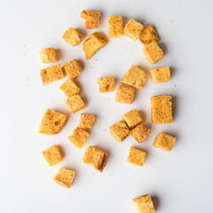 Square breadcrumbs. Oven-fried golden brown bread crumbs. White background