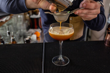 Bartender making a coffee based cocktail, cocktail in glass cup