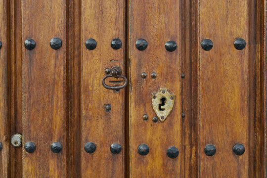 Puerta antigua de madera con herrajes oxidados