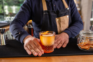 Time for some alcohol beverage, bartender serving a cocktail on the bar