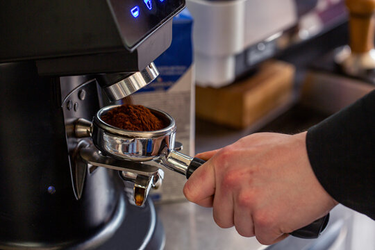 Barista preparing an espresso in a coffee machine, close up fresh coffee