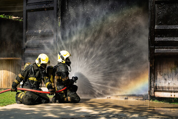 Firefighters are conducting fire drills by spraying water to extinguish the raging fire.