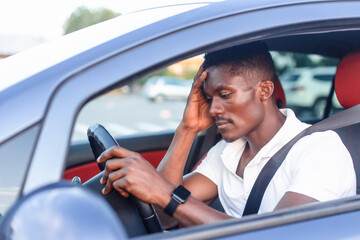 An African-American man driving a car. Human emotions