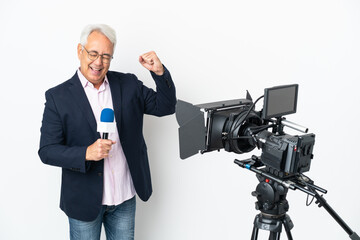 Reporter Middle age Brazilian man holding a microphone and reporting news isolated on white background celebrating a victory