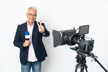 Reporter Middle age Brazilian man holding a microphone and reporting news isolated on white background smiling and showing victory sign