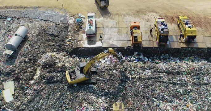 Garbage trucks are working in the waste sorting plant.