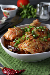 Georgian meat dish chashushuli with chicken, onion and tomato on gray background