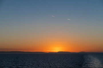 Sunset at sea. Seascape, blue sea.  Calm weather. View from cargo vessel.