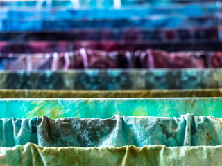 Closeup of colorful hand-dyed wet cotton fabrics drying on drier