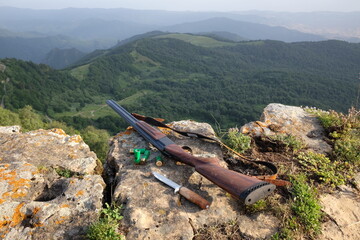 hunting gun and knife in mountains