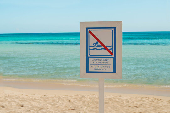 aviso de precausion en la orilla de la playa, no nadar aqui.
