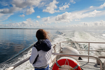 Teenager girl looking at the ocean from a deck of a cruise ship. Galway bay, Ireland. The model...