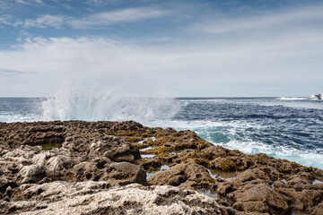 Ocean wave crushes on stone coastline of Inishmore, Aran Islands, County Galway, Ireland. Irish landscape. Cloudy sky