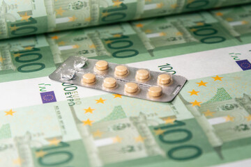 Money (euro banknotes) and medicines in tablets. The rise in drug prices.