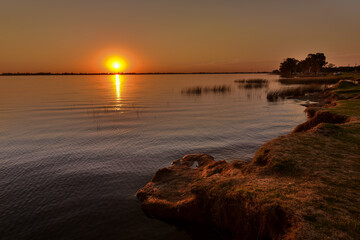 Last moments of the day over a lagoon with calm waters and water plants with beautiful colours in...