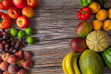 Seasonal fruits and vegetables on wooden plank. Red apples, peaches and Paraguayans, red limes and grapes, bananas and melons, tomatoes and watermelons.