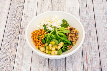 stewed lentil salad with crumbled fresh cheese, lamb's lettuce and spinach sprouts, apple squares and chopped California walnuts