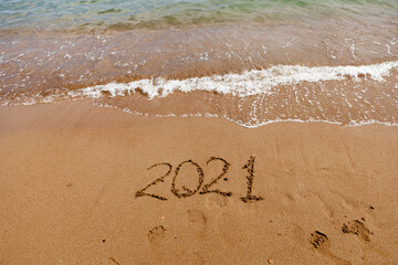 inscription on the sand 2021. symbol 2021 on the coast, overlooking the sea. Summer holidays in the new season.