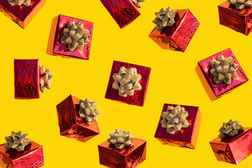 red gift box with gold bow on yellow background. pattern, levitation