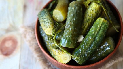Pickles in a bowl on a wooden surface. Probiotics and fermented foods.