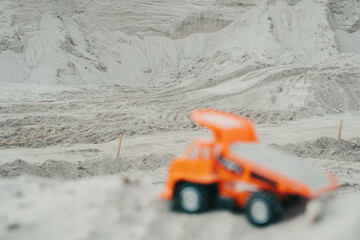 Truck in a sand quarry. Large excavator loads rock with iron or bauxite mining dump truck in a quarry against the sky