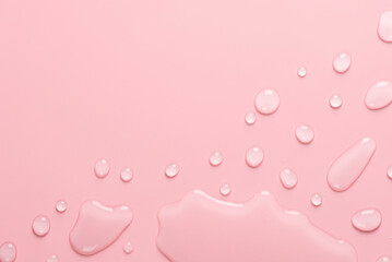 Splash of Water and drops on a pastel pink background. Water texture close up. Backdrop glass covered with drops of water. Water bubbles