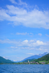 View of Weissensee, austria and the church in the distance against a blue sky
