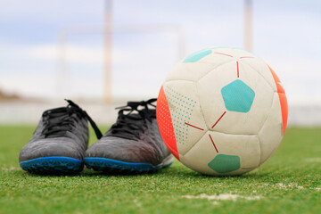 soccer boots and the ball on the grass © Matias