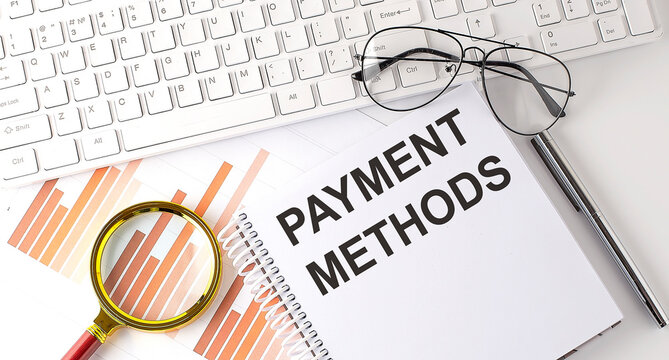 PAYMENT METHODS text written on a notebook with keyboard, chart,and glasses