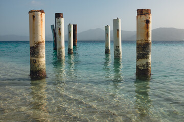 Fototapeta premium Old Pier Ruins in Caribbean Water at Île à Rat beach in Haiti