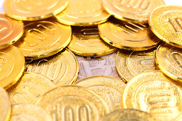 A bitcoin under a large number of gold coins