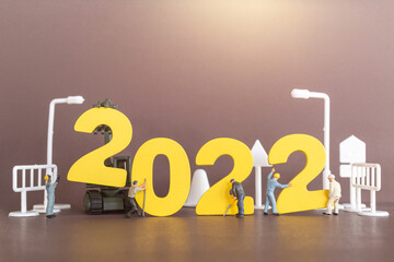 Miniature people worker team build number 2022 , Happy new year concept