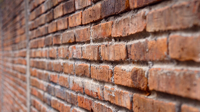 Fototapeta Red brick wall from the side, focus selected, blur on the far side