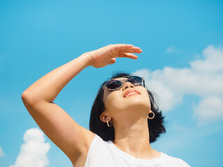 Woman in summertime. Smiling beautiful Asian woman short hair wearing sunglasses and white...