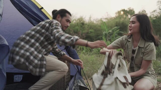 A couple goes camping in the woods with their wife helping to deliver their camping bags and belongings. Couple doing nature tourism in vacation. Social distance tourism concept.