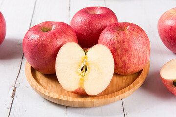 Ripe red apples on white wooden background