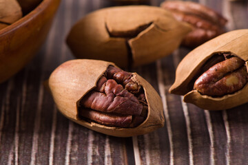 Pecan in bag on wooden table. Heap or stack of pecan . Pecan background.