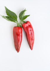 Red ''Corno di Toro'' Peppers with Leaves on White Background