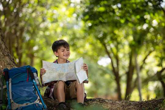 American Little Boy Child Reading Map In The Forest  Trail Adventure At Summer Holiday