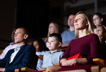 Teenage son watches spectacle with his parents in the theater