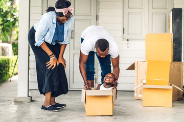 Portrait of enjoy happy love black family african american father and mother with little african girl smiling sitting in cardboard box at new home unpacking during move and having fun